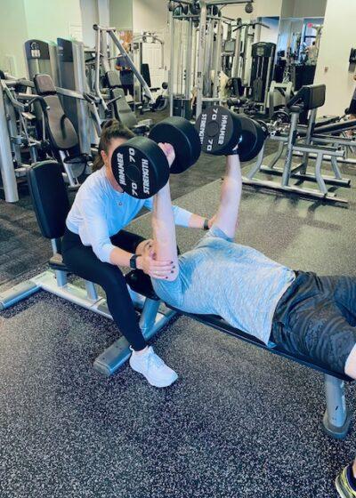 Georgia Personal Training Team Member spotting a dumbbell press for client Peter. New father, business owner, and client of GPT for nearly 2 years.